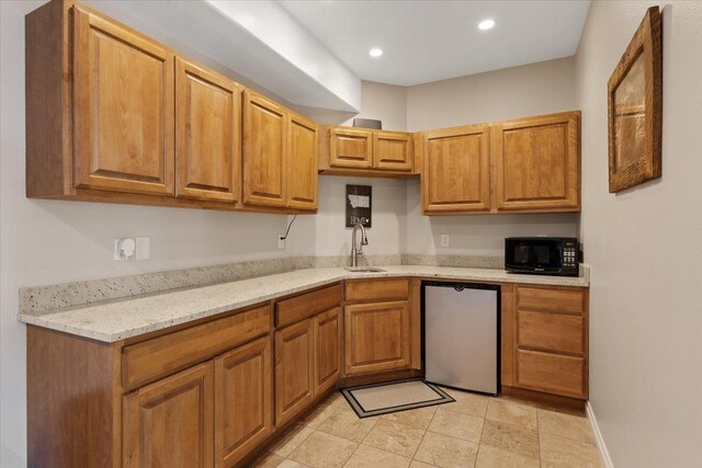 7105 S Saddle Ridge Ln, Spokane Valley, WA 99016 - kitchen featuring black microwave, dishwashing machine, light stone countertops, recessed lighting, and brown cabinetry