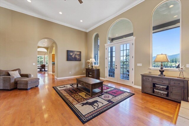 7105 S Saddle Ridge Ln, Spokane Valley, WA 99016 - living room with arched walkways, french doors, light wood-type flooring, recessed lighting, and crown molding