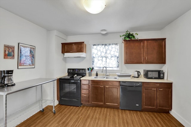 2505 W Mallon Ave, Spokane, WA 99201 - kitchen with black appliances, under cabinet range hood, light wood-style flooring, and light countertops