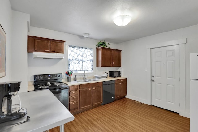 2505 W Mallon Ave, Spokane, WA 99201 - kitchen featuring black appliances, under cabinet range hood, light wood-type flooring, and light countertops