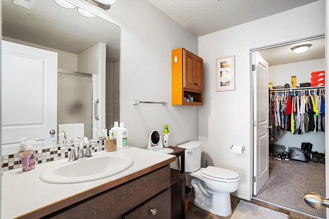 124 S Lone Tree Ave, Spokane Valley, WA 99016 - bathroom with vanity, a shower stall, a spacious closet, and a textured ceiling
