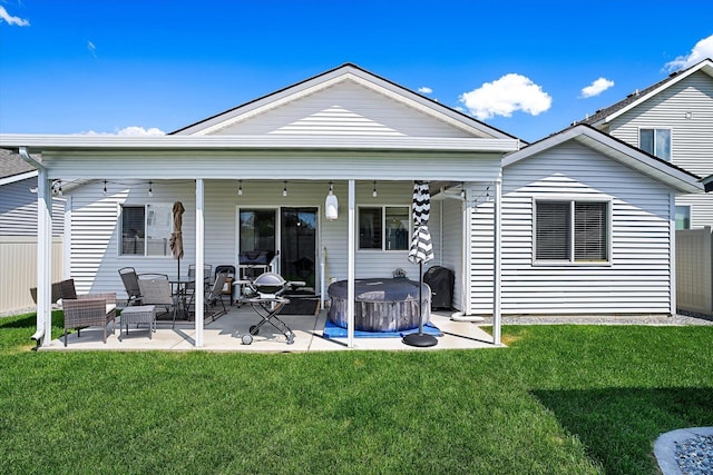 124 S Lone Tree Ave, Spokane Valley, WA 99016 - back of property with a hot tub, a patio, and a lawn
