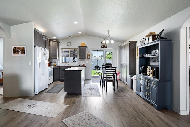 124 S Lone Tree Ave, Spokane Valley, WA 99016 - kitchen with white appliances, vaulted ceiling, arched walkways, a chandelier, and a center island