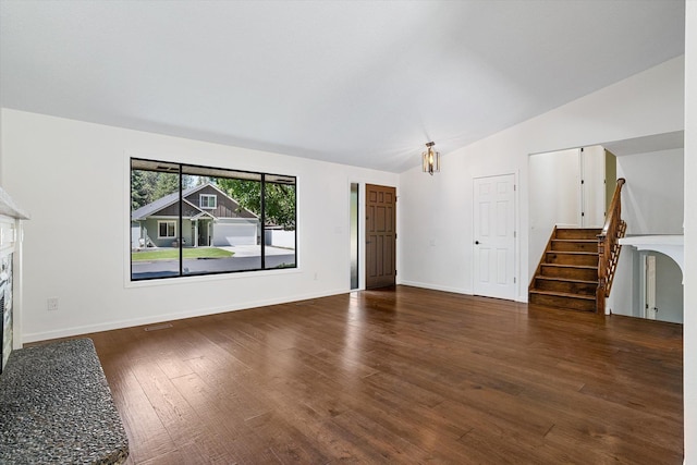 317 E Eaton Ave, Spokane, WA 99218 - unfurnished living room with a fireplace, lofted ceiling, wood finished floors, and stairs