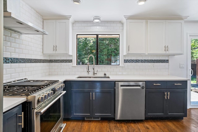 317 E Eaton Ave, Spokane, WA 99218 - kitchen featuring stainless steel appliances, wall chimney range hood, white cabinetry, tasteful backsplash, and light countertops