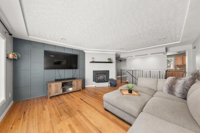 1718 S Bolivar Rd, Spokane Valley, WA 99037 - living room with a textured ceiling, light wood finished floors, and a brick fireplace
