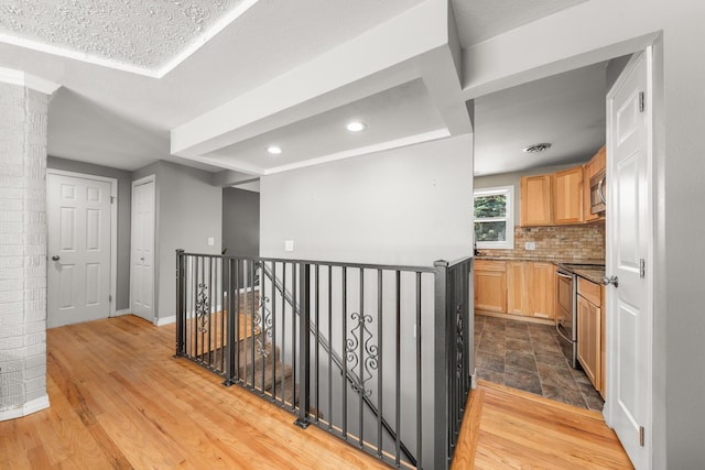 1718 S Bolivar Rd, Spokane Valley, WA 99037 - hall featuring an upstairs landing, recessed lighting, light wood finished floors, and decorative columns