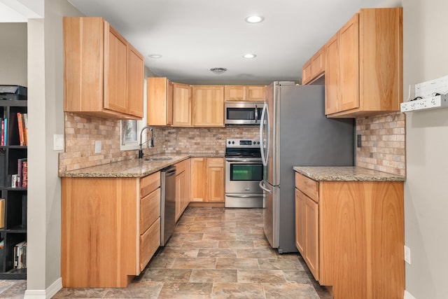 1718 S Bolivar Rd, Spokane Valley, WA 99037 - kitchen with appliances with stainless steel finishes, light brown cabinetry, light stone countertops, decorative backsplash, and recessed lighting