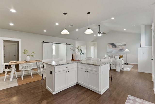 37818 N Grove Rd, Deer Park, WA 99006 - kitchen featuring ceiling fan, a barn door, a breakfast bar area, white cabinetry, and dark wood-style floors