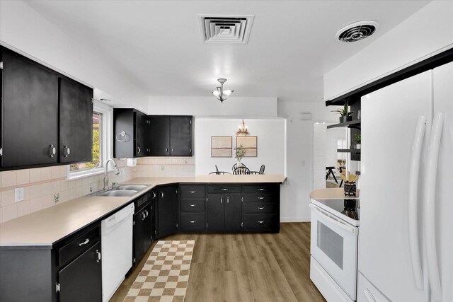 1102 S Buena Vista Dr, Spokane, WA 99224 - kitchen featuring white appliances, dark cabinets, tasteful backsplash, light wood-style flooring, and light countertops