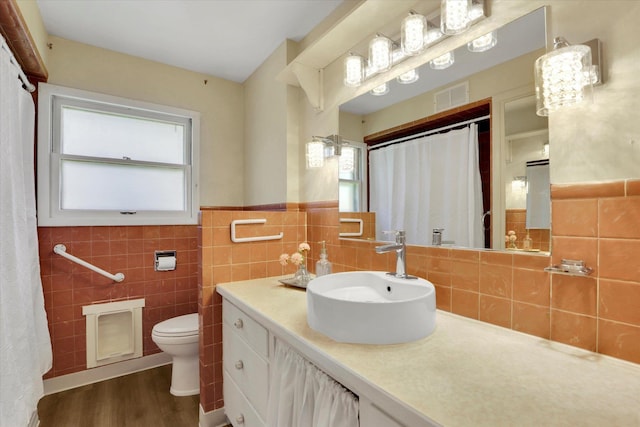1102 S Buena Vista Dr, Spokane, WA 99224 - full bath featuring healthy amount of natural light, wood finished floors, tile walls, vanity, and wainscoting