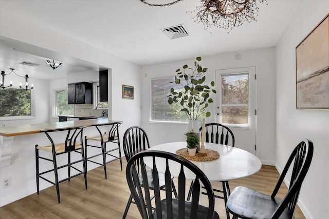 1102 S Buena Vista Dr, Spokane, WA 99224 - dining area featuring a chandelier, light wood-type flooring, and healthy amount of natural light