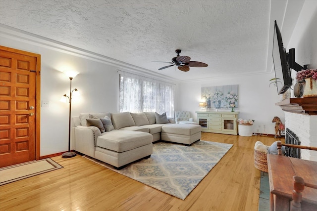 1310 N Woodruff Rd, Spokane Valley, WA 99206 - living area featuring ceiling fan, a textured ceiling, light wood-style floors, ornamental molding, and a brick fireplace