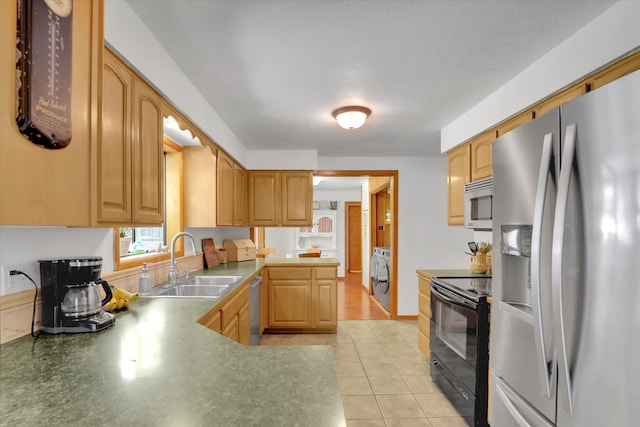 1310 N Woodruff Rd, Spokane Valley, WA 99206 - kitchen featuring appliances with stainless steel finishes, washer / dryer, light tile patterned flooring, and a peninsula