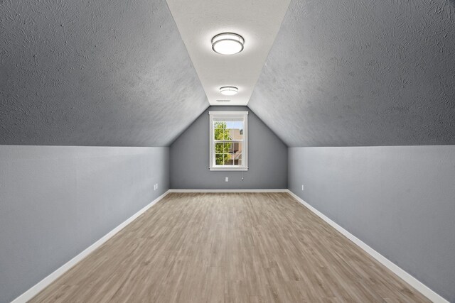 5214 S Myrtle Ln, Spokane, WA 99223 - bonus room featuring wood finished floors, a textured ceiling, and vaulted ceiling