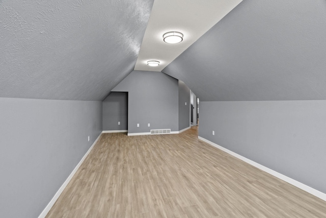 5214 S Myrtle Ln, Spokane, WA 99223 - additional living space with light wood-style flooring, vaulted ceiling, and a textured ceiling