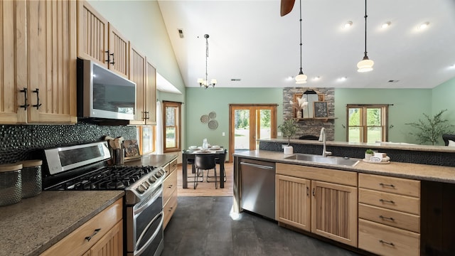 38415 N Hatch Rd, Deer Park, WA 99006 - kitchen with appliances with stainless steel finishes, light brown cabinetry, a stone fireplace, vaulted ceiling, and decorative backsplash