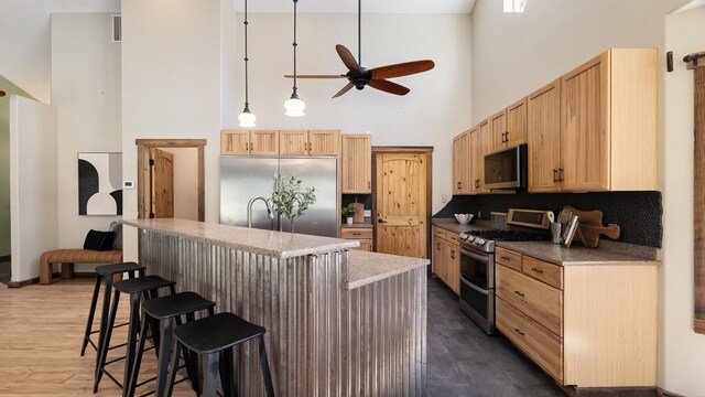 38415 N Hatch Rd, Deer Park, WA 99006 - kitchen featuring stainless steel appliances, a towering ceiling, a ceiling fan, backsplash, and an island with sink