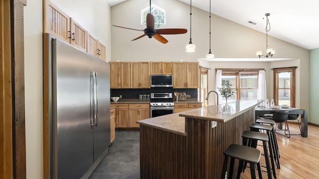 38415 N Hatch Rd, Deer Park, WA 99006 - kitchen with stainless steel appliances, high vaulted ceiling, ceiling fan, light brown cabinets, and a kitchen breakfast bar