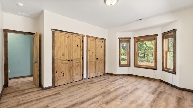 38415 N Hatch Rd, Deer Park, WA 99006 - unfurnished bedroom featuring light wood finished floors, two closets, and multiple windows