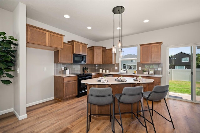 1840 N Wolfe Penn St, Liberty Lake, WA 99019 - kitchen featuring black appliances, brown cabinets, light countertops, and recessed lighting