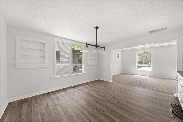 215 E 18th Ave, Spokane, WA 99203 - unfurnished dining area featuring a textured ceiling, dark wood-type flooring, and built in features