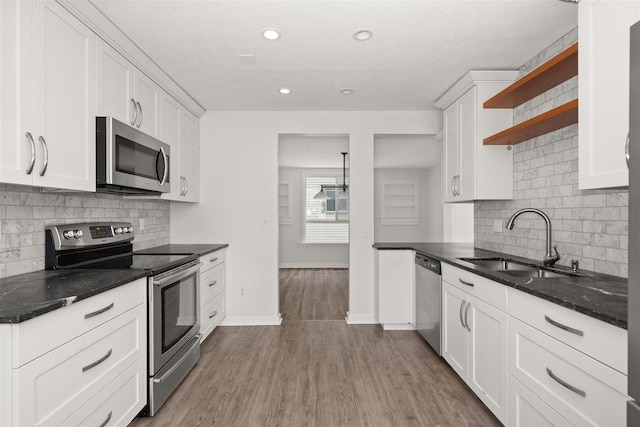 215 E 18th Ave, Spokane, WA 99203 - kitchen with appliances with stainless steel finishes, open shelves, decorative backsplash, white cabinetry, and recessed lighting