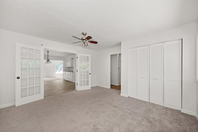 215 E 18th Ave, Spokane, WA 99203 - unfurnished bedroom with french doors, carpet floors, a closet, and a ceiling fan