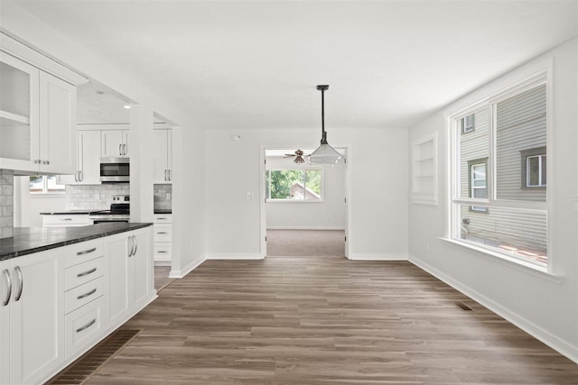 215 E 18th Ave, Spokane, WA 99203 - kitchen featuring appliances with stainless steel finishes, white cabinets, tasteful backsplash, dark countertops, and hanging light fixtures