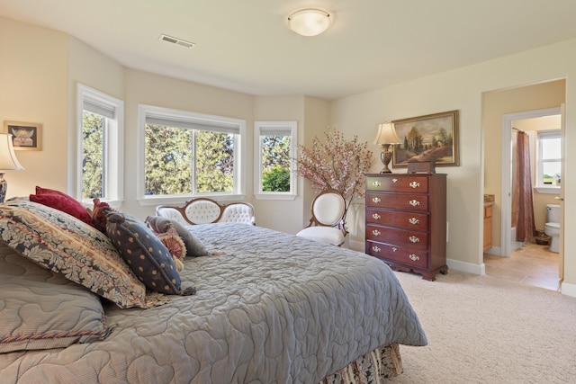 6815 S Palouse Hwy, Spokane, WA 99223 - bedroom with multiple windows, light colored carpet, and ensuite bathroom