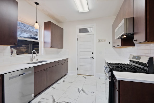 1434 W 8th Ave, Spokane, WA 99204 - kitchen featuring appliances with stainless steel finishes, light countertops, light marble finish floors, decorative light fixtures, and dark brown cabinets