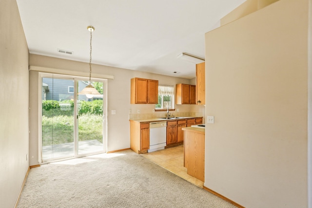 17506 E 3rd Ln, Greenacres, WA 99016 - kitchen featuring white dishwasher, light countertops, pendant lighting, light colored carpet, and brown cabinetry