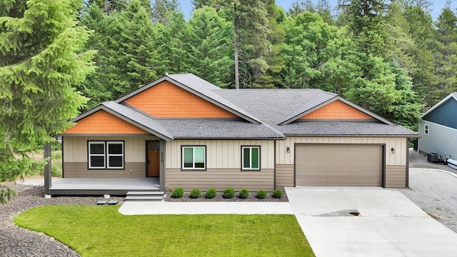 826 Thomas Ln, Newport, WA 99156 - craftsman house featuring roof with shingles, an attached garage, driveway, a front yard, and a porch