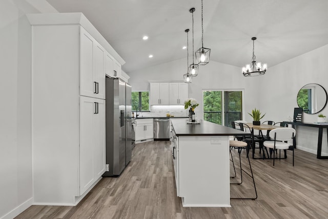 826 Thomas Ln, Newport, WA 99156 - kitchen with appliances with stainless steel finishes, a kitchen island, a kitchen breakfast bar, dark countertops, and white cabinetry