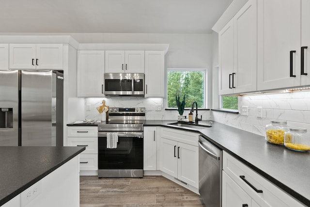 826 Thomas Ln, Newport, WA 99156 - kitchen with appliances with stainless steel finishes, dark countertops, white cabinets, and tasteful backsplash
