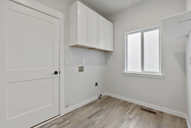 826 Thomas Ln, Newport, WA 99156 - washroom featuring hookup for an electric dryer, washer hookup, cabinet space, and light wood-type flooring