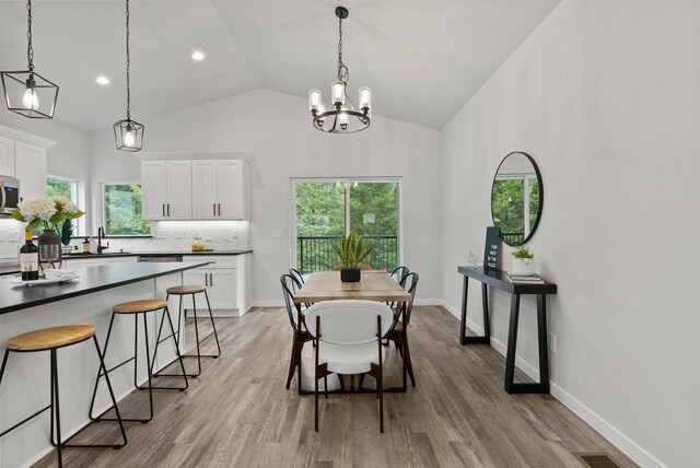 826 Thomas Ln, Newport, WA 99156 - dining room with plenty of natural light, lofted ceiling, light wood finished floors, a chandelier, and recessed lighting
