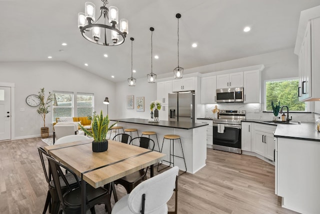 826 Thomas Ln, Newport, WA 99156 - dining room featuring healthy amount of natural light, recessed lighting, vaulted ceiling, light wood-style flooring, and a chandelier