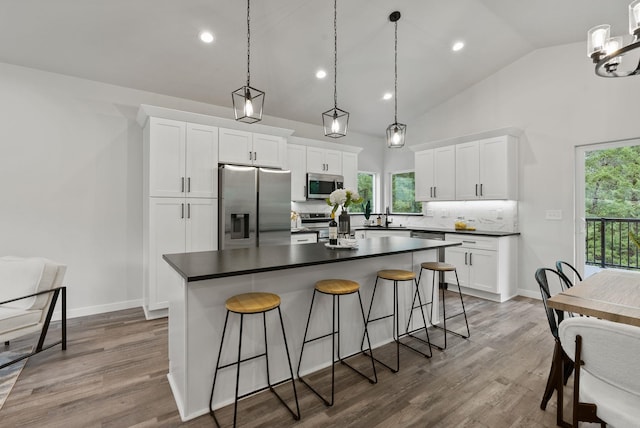 826 Thomas Ln, Newport, WA 99156 - kitchen featuring stainless steel appliances, dark countertops, backsplash, a breakfast bar, and white cabinetry