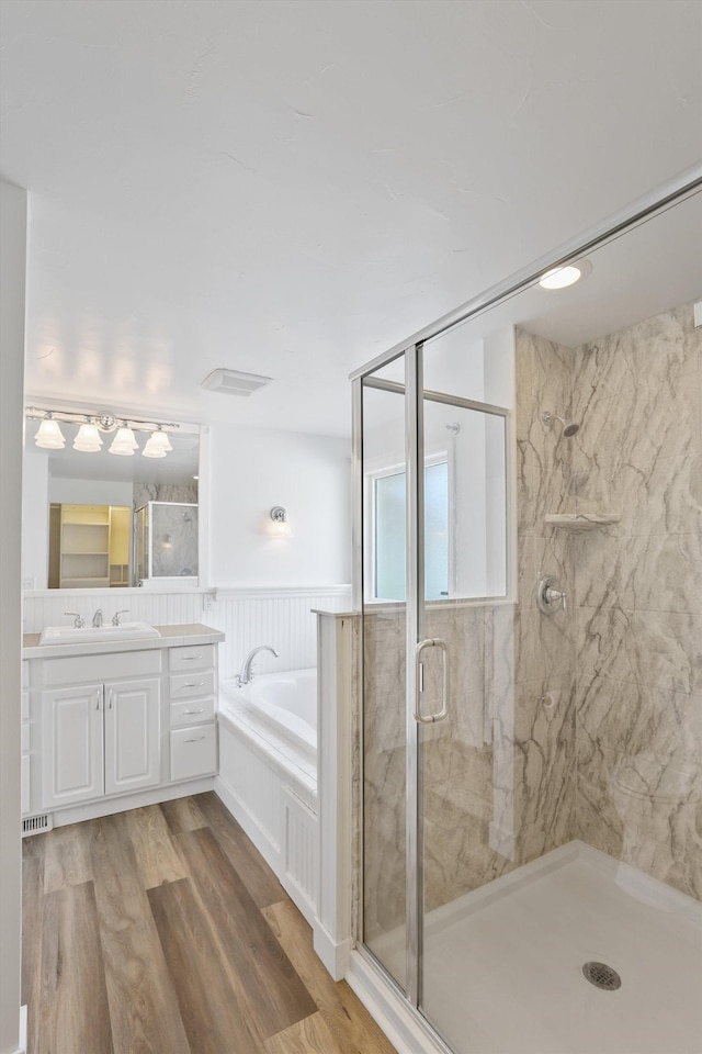 4523 N Royal Ct, Spokane, WA 99205 - bathroom featuring a garden tub, vanity, a shower stall, wood finished floors, and a wainscoted wall