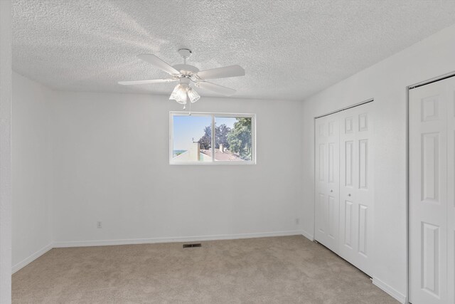 4523 N Royal Ct, Spokane, WA 99205 - unfurnished bedroom with light carpet, a textured ceiling, and a ceiling fan