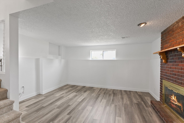 4523 N Royal Ct, Spokane, WA 99205 - basement featuring a brick fireplace, stairway, wood finished floors, and a textured ceiling