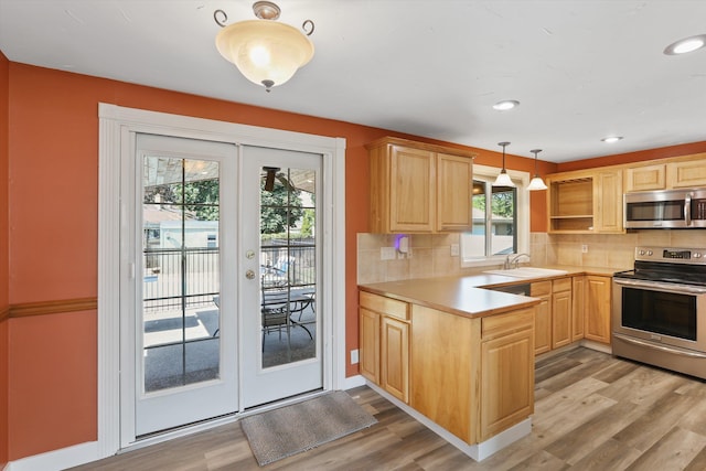4523 N Royal Ct, Spokane, WA 99205 - kitchen featuring stainless steel appliances, light brown cabinetry, light wood-style flooring, light countertops, and decorative backsplash