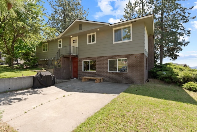 6221 N Highview Ln, Spokane Valley, WA 99217 - view of front of home with brick siding, a patio area, and a front yard