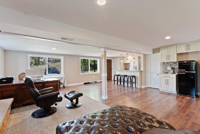 6221 N Highview Ln, Spokane Valley, WA 99217 - living area featuring ornate columns, light wood-style floors, a desk, and recessed lighting