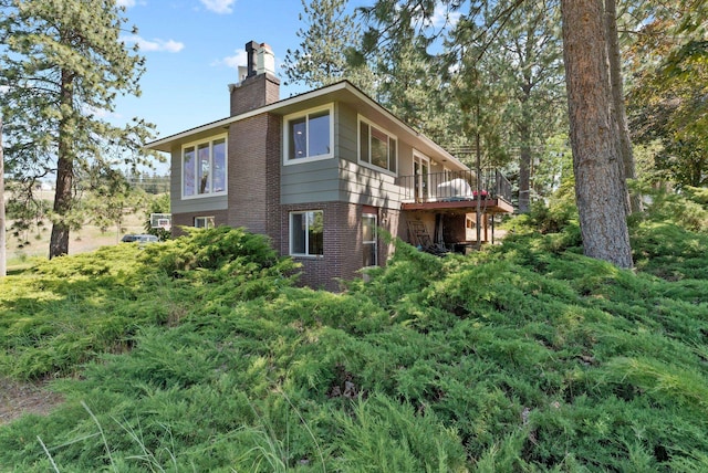 6221 N Highview Ln, Spokane Valley, WA 99217 - view of property exterior with brick siding, a chimney, and a wooden deck