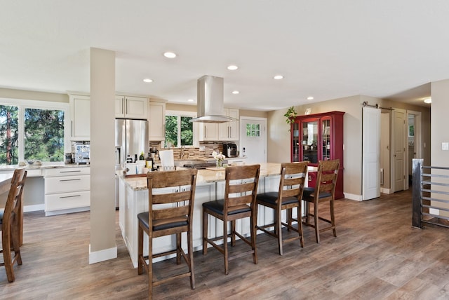 6221 N Highview Ln, Spokane Valley, WA 99217 - kitchen with island range hood, backsplash, recessed lighting, light wood-style flooring, and a center island