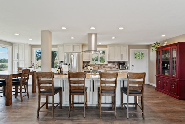 6221 N Highview Ln, Spokane Valley, WA 99217 - kitchen featuring stainless steel refrigerator with ice dispenser, island exhaust hood, healthy amount of natural light, recessed lighting, and a breakfast bar area