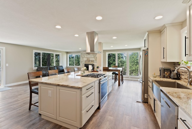 6221 N Highview Ln, Spokane Valley, WA 99217 - kitchen with appliances with stainless steel finishes, island exhaust hood, a kitchen island, wood finished floors, and recessed lighting