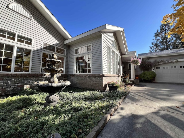 1703 W 25th Ave, Spokane, WA 99224 - view of home's exterior featuring brick siding, an attached garage, and concrete driveway